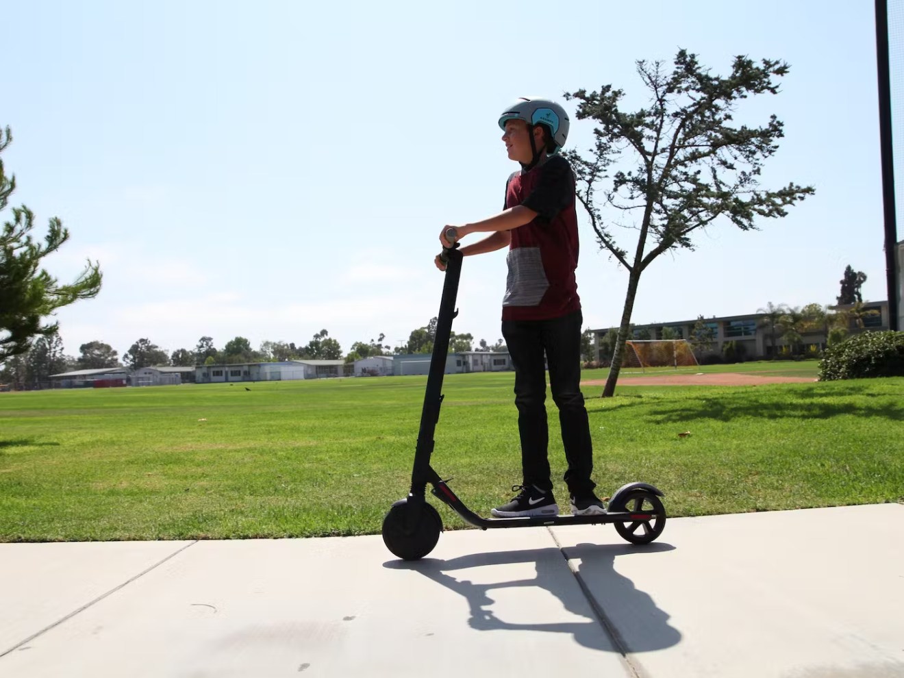 a man riding a skateboard on top of a grass covered field